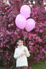 June 1 is Children's Day. Happy little boy with balloons and flowering apple tree in spring garden....