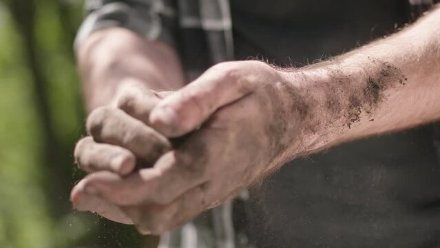 The worn-out hands of the gardener, the farmer's dirty hands. Dry soil in the hands, drought.