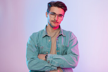 Men's studio portrait of a handsome hipster guy with a haircut and vintage glasses in a casual...