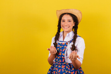 Girl wearing typical clothes for Festa Junina. calling with the hands, come, inviting. For the...
