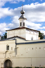 Medieval church building with a dome and a cross against a blue sky