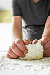 Man Hands kneading dough for pizza on the wooden table