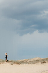 girl in a black long dress in a sandy desert