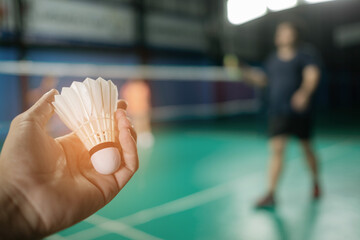 Hand hold badminton shuttlecock with blur background
