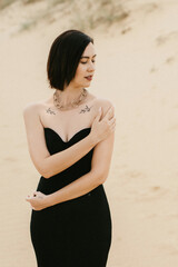 girl in a black long dress in a sandy desert