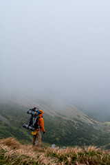 Obraz premium Tourist with a backpack on a background of picturesque Carpathians, picturesque autumn Carpathians.