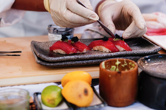Japanese Omakase chef making Chutoro Sushi (Medium Fatty Bluefin Tuna) neatly by hands. Japanese traditional and luxury meal.