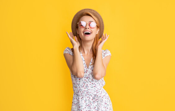 glad woman in straw hat and sunglasses on yellow background