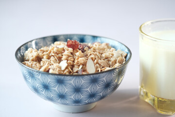 Home Made Musli in a bowl, glass of milk and bread on table 