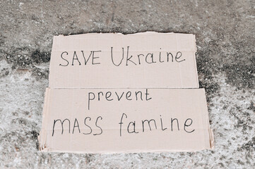 Save Ukraine is written on a piece of cardboard.