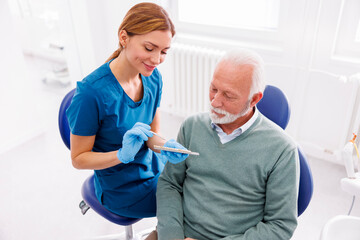 Dentist showing dentail veneers color palette to patient