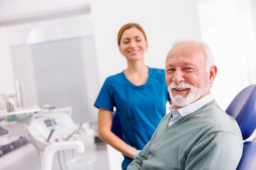 Senior man sitting at dentist office satisfied smiling