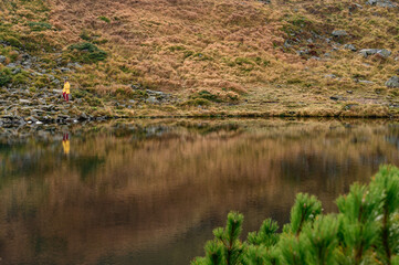 Light waves on Lake Nesamovite, a reflection in the water of a woman, a girl walking near Lake Nesamovite in bright clothes.