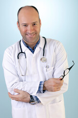 Handsome Doctor is Posing and Smiling Againt Blue Background