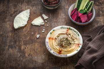 Chickpeas hummus with olive oil and smoked paprika with cucumber and radish
