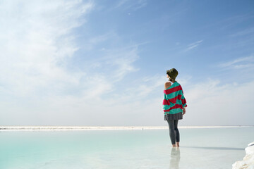 asian female tourist standing in water of a salt lake