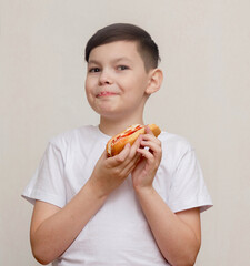 Little boy eats a huge hot-dog sandwich