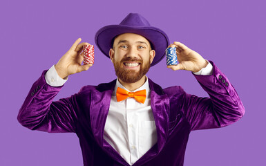 Happy man playing poker and having fun. Funny studio shot of goofy guy in suit, hat and bowtie...