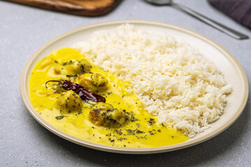 kadhi pakora served with steam rice in a ceramic plate
