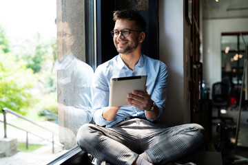 Young businessman using digital tablet in the office. Handsome man learning online