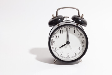 black vintage style alarm clock isolated on a white background