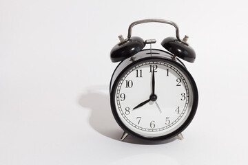 black vintage style alarm clock isolated on a white background