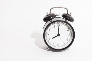 black vintage style alarm clock isolated on a white background