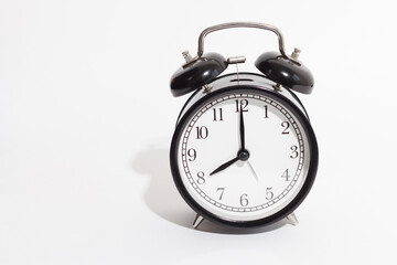 black vintage style alarm clock isolated on a white background