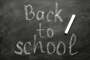 Fototapeta premium Inscription back to school on blackboard on green background. Concept - a new academic year