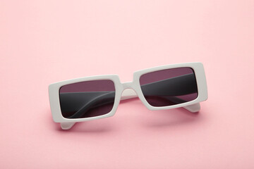 White sunglasses on pink pastel background, top view, flat lay, minimalistic concept of summer, vacation.