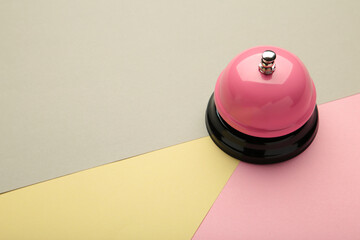Pink service bell on pastel colorful background.