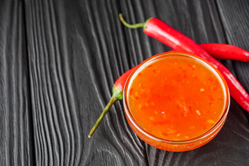 sweet chili sauce on a black wooden rustic background