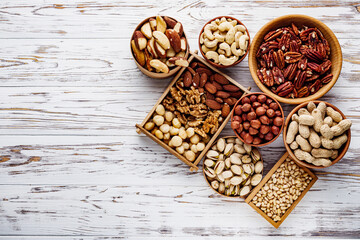set of different nuts on a white wooden rustic background