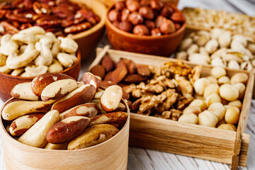 set of different nuts on a white wooden rustic background