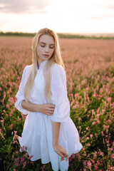 Fototapeta na wymiar Beautiful woman in the blooming field. Nature, vacation, relax and lifestyle. Summer landscape.