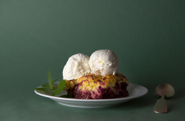 Delicious grated cherry and blueberry pie with vanilla ice cream balls on a green background. Horizontal selective focus. summer desserts. for menus and ads. copy space