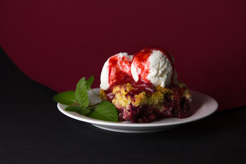 Delicious grated strawberry pie with vanilla ice cream balls, poured with strawberry syrup on a bright background.decorated with a sprig of fresh mint. close-up. selective focus. copy space