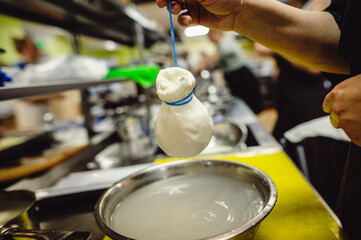 Italian hard cheese silano or caciocavallo in cheesemaker hands. The home-made cheese maker produces handmade caciocavallo. Concept: tradition, italy, mozzarella.The process of making mozzarella.