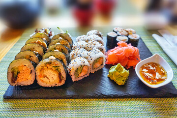 Sliced rolls of salmon sushi with ginger, wasabi and honey sauce