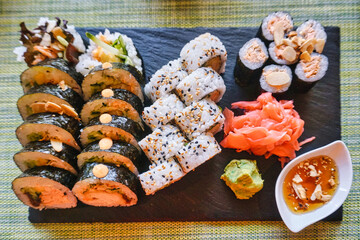 Sliced rolls of salmon sushi with ginger, wasabi and honey sauce