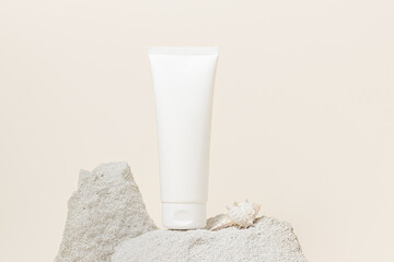 White unbranded face cream tube on stone podium, summer concept skin care