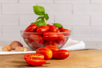 Tomates cherry orgánicos acompañados de ajo, aceite de oliva, sobre una mesada de mármol con luz de día. Concepto de alimentación saludable.