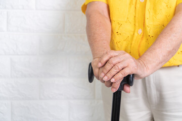 Asian elderly woman holding a walking stick on isolate background. The concept aging society That needs time and grandchildren to come back to caring for healthcare