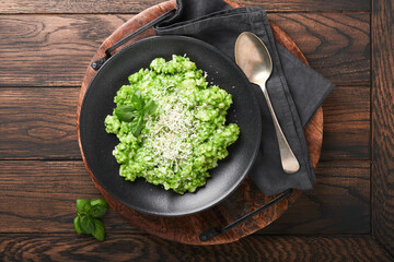 Italian risotto. Delicious risotto with pesto sauce or wild garlic pesto, basil, parmesan cheese and glass of white wine on old wooden table background. Italian dinner. Top view with copy space.