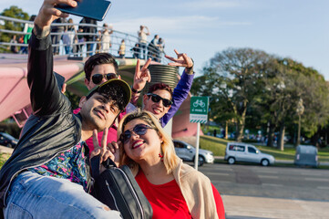 group of friend on the street standing smiling taking a selfie with the phone, copy space.