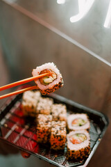 girl holding salmon sushi with chopsticks