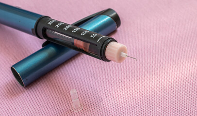 Insulin pen injector. Insulin pen fill with needle on pink background. Diabetes Day.