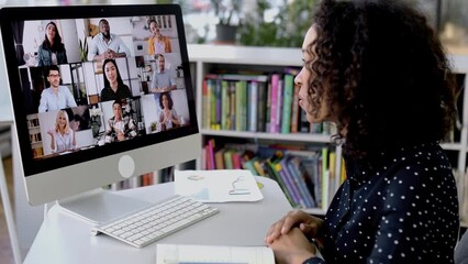 Successful African american business woman, sits in front of a computer screen, conducts conversation with international colleagues, discusses a future project, perspective, business strategy, plan