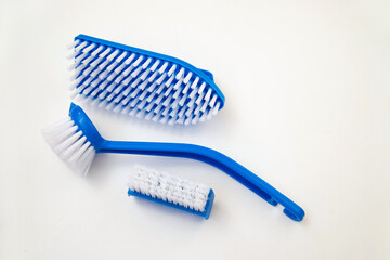 Close-up, cleaning brush on a white background. A brush with a white pile and a blue handle. Convenient equipment for cleaning the house.