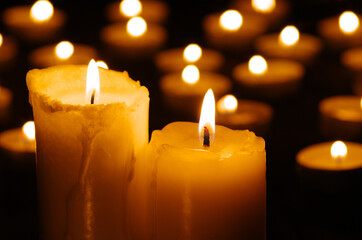 Two burning candles in the dark